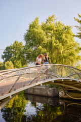 Two middle-aged sisters spending a summer morning in the park by a lake relaxing and having fun.