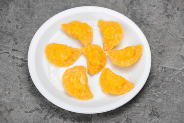 Fried dumplings in a white plate on a gray background