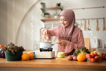 Happy Muslim woman cooking in modern Kitchen