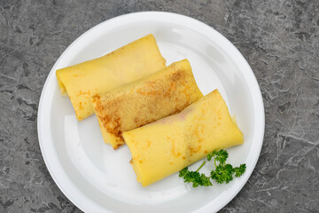 three pancakes with filling in a white plate macro photo