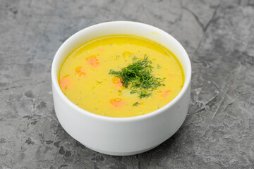 Pea soup in a white plate on a gray concrete background