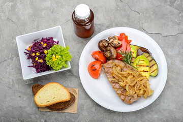 set steak grilled vegetables with mushrooms and salad on a gray background