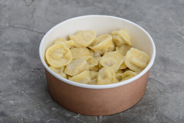 dumplings with meat and sour cream in a disposable container