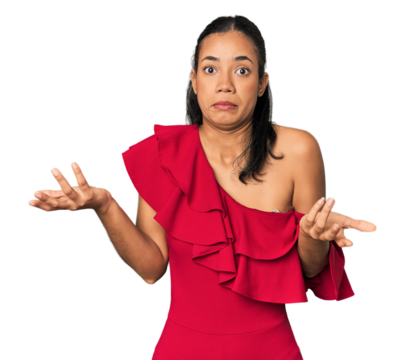 Young Filipino woman in studio doubting and shrugging shoulders in questioning gesture.