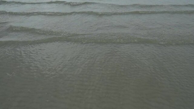 serene b roll scene with gentle ocean waves a distant island and an overcast sky creating a calm and contemplative atmosphere in nature