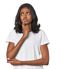 Portrait of a young Indian woman looking sideways with doubtful and skeptical expression.