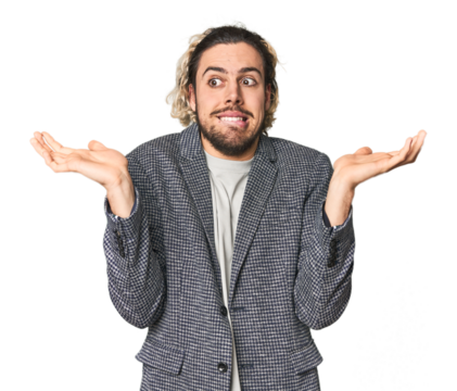 Young businessman in casual blazer confused and doubtful shrugging shoulders to hold a copy space.