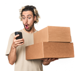 Young Caucasian man receiving packages, on phone in studio