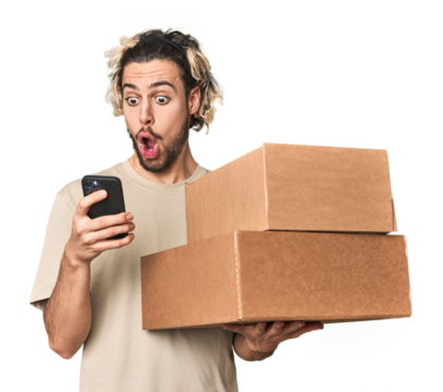 Young Caucasian man receiving packages, on phone in studio