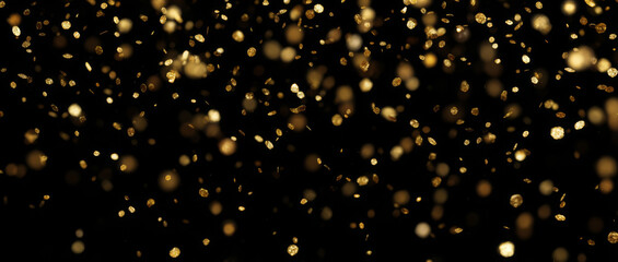 Golden glitter particles. Gold confetti with bokeh effect falling on black background creating festive shimmer. Decoration for party, holiday or celebration.