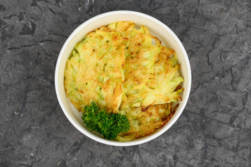 Ukrainian dish deruny in disposable dishes on a gray background