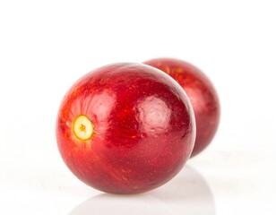 Obraz premium Two vibrant red berries against a white background