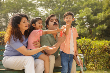 Parents With Children Blowing Bubbles