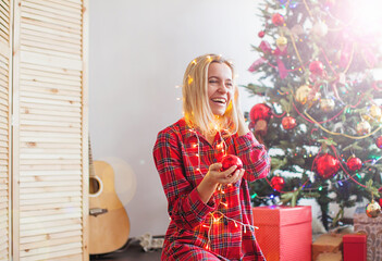 Happy woman wrapped in Christmas lights