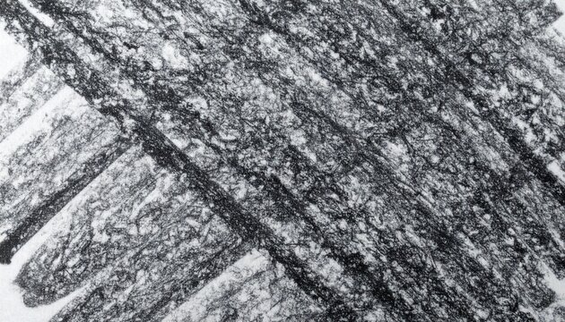 A detailed macro photograph of a black crayon rubbing, revealing a textured, cross-hatched pattern on white paper.