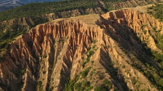 Aerial footage of sandstone towers at the Stob Earth Pyramids Bulgaria unique natural wonder with countryside scenery.