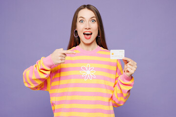 Young woman wears yellow sweatshirt casual clothes hold in hand point index finger on mock up of...