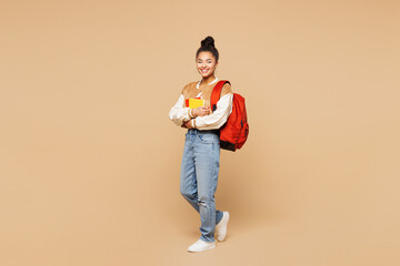 Full length side view young smart girl student wears casual clothes backpack bag hold books stand...