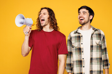 Young two friends buddies men they wear casual clothes together hold in hand megaphone scream...