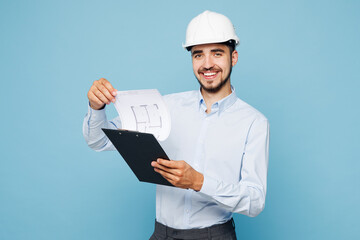 Young smiling architect engineer designer employee man wears white clothes hardhat hold clipboard...