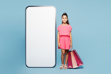 Little kid girl 9-10 years old wears pink clothes hold paper package bags after shopping big huge...