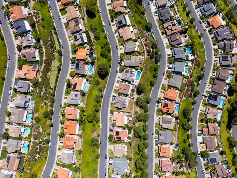 Drone view of  suburban block with swimming pools and landscaped lots