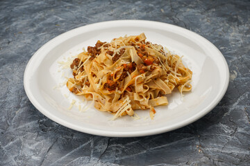 stewed cabbage with mushrooms in a white plate on a gray background