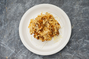 stewed cabbage with mushrooms in a white plate on a gray concrete background