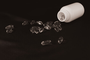Omega3 gel capsules on black background. Soft Fish Oil Capsules. Floating fatty acids softgel...