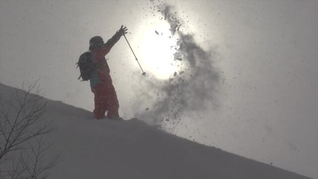 Skieur jetant de la neige avec ces skis bras ouvert