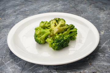 boiled broccoli in a white plate on a background