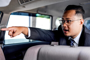 Businessman In Suit Pointing With Urgency While Seated In Car