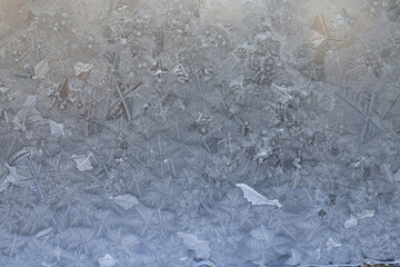 white winter background, frosty patterns on glass, abstract backdrop of ice and snow crystals in a...