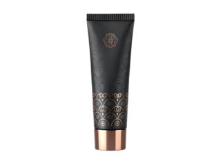 Matte black cosmetic tube with gold art deco pattern and copper cap isolated on a transparent background