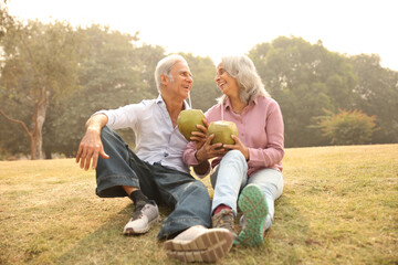 Senior Couple Enjoying Fresh Coconut Water In A Park