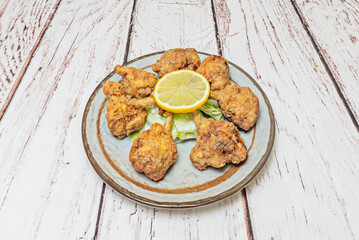 Fried wings glazed with spicy tamarind sauce, garnished with crushed peanuts and cilantro leaves
