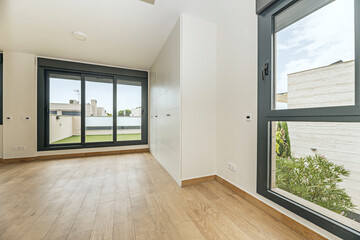 Undecorated master suite with a walk-in wardrobe in glossy white wood, subtly embossed doors, and a...