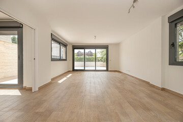 Empty social area with an open layout, glossy porcelain floors, and a floating staircase connecting to the upper level