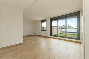 Spacious contemporary living room with a double-height ceiling, pristine white walls, and a visual connection to the outdoor garden.
