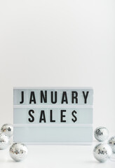 A light box with the word January sales the s being represented by a dollar sign.