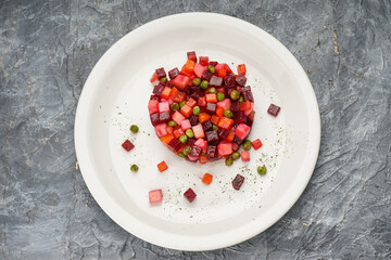 salad veggie in a white plate on a gray concrete background
