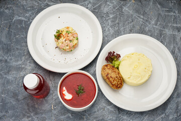 set of rice with cutlet, salad and kharcho soup on the background