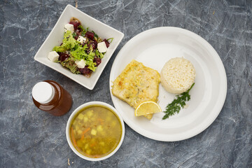 set of rice with fish, salad and soup on the background
