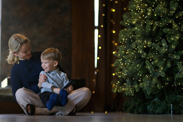 a boy and a mother in a New Year's decorated room in oriental style clothes