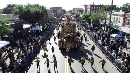 A vibrant street parade fills the city street with a joyous atmosphere.