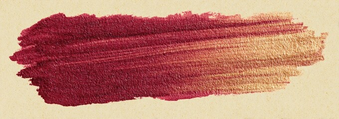 A textured paint stroke of deep burgundy transitioning to a gold tone