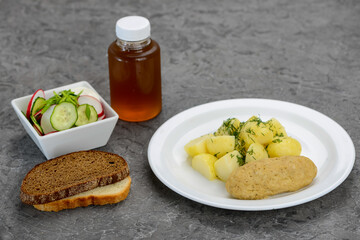 lunch potatoes with a cutlet and salad with juice and bread