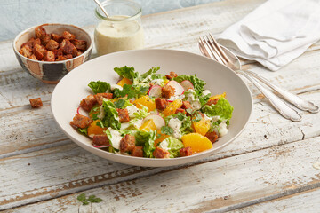 Caesar salad with orange and radishes