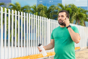 Concentrated sportsman making phone call while walking outdoors