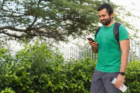 Happy sportsman checking fitness app on smartphone after training - Powered by Adobe